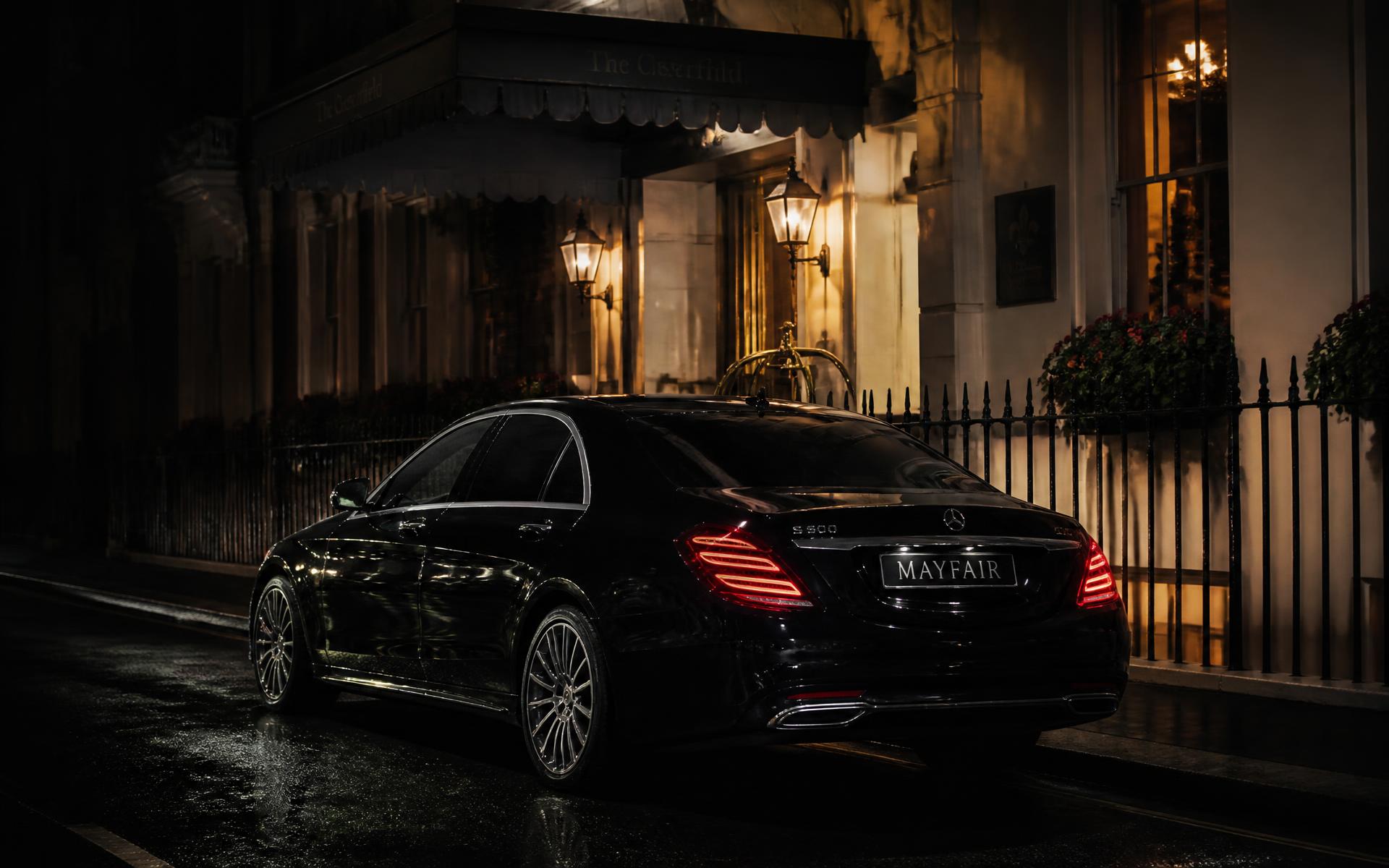 Black luxury chauffeur car waiting outside a Mayfair hotel in London at night