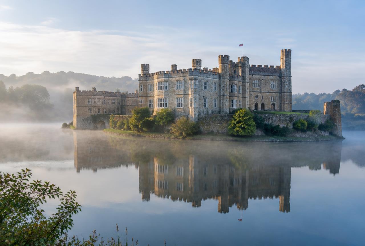 Leeds Castle on its moat lake in morning mist on a private Leeds Castle and Canterbury tour